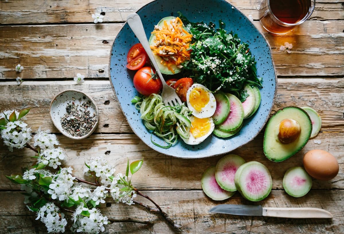 Gedeckter Frühstückstisch mit Obst, Müsli und Tee in natürlichem Licht